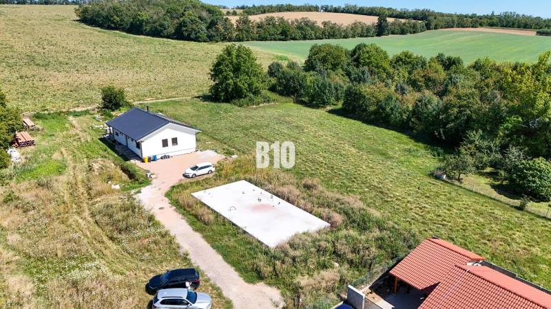 Grundstücksansicht für Wohnzwecke in Čeľadice umfasst ein Haus, Grünflächen und Autos.