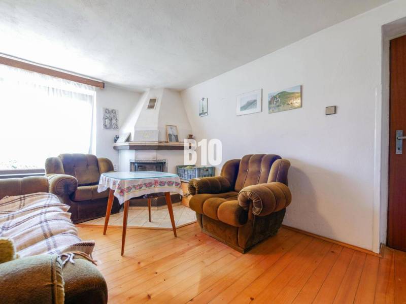 Ein Einfamilienhaus mit Kamin, bequemen Sesseln und einem Fußboden mit Holzdekor.