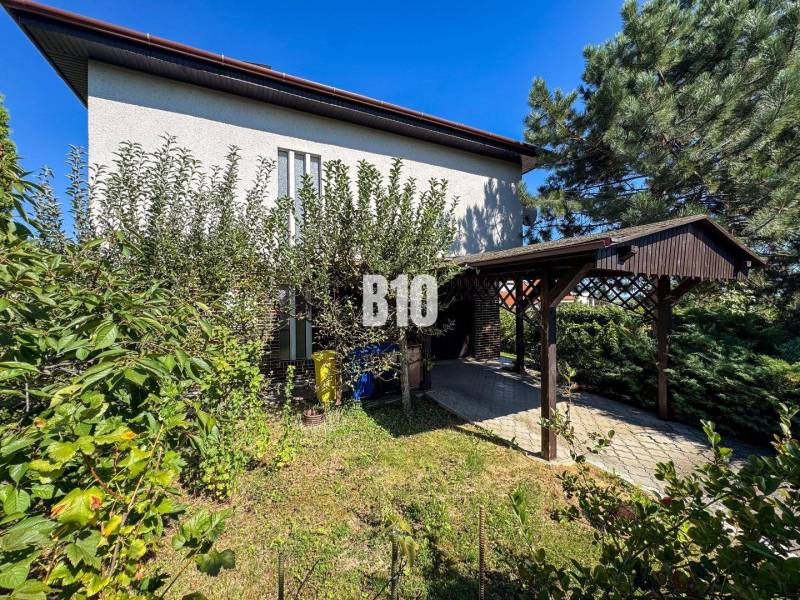 Ein Einfamilienhaus in der Kamenna-Straße in Nitra, umgeben von Grünflächen und einem Carport.