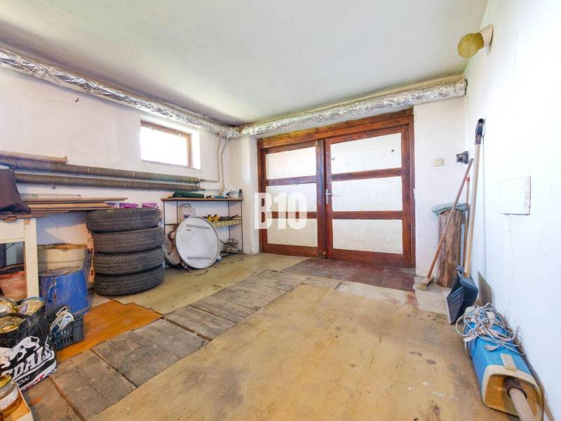 Garage in einem Einfamilienhaus mit Holztüren und einem Boden in Holzdekor-Optik.