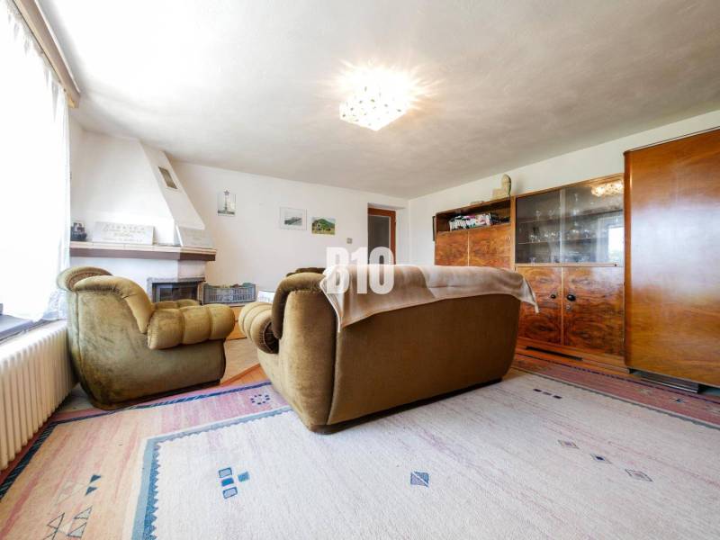 Wohnzimmer mit Kamin und Retro-Möbeln in einem Einfamilienhaus, Boden mit Holzdekor.