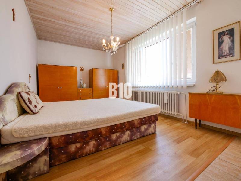 Schlafzimmer mit Holzboden in einem Einfamilienhaus, mit Möbeln und Kronleuchtern.