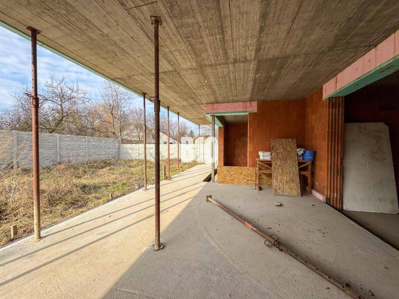 Der Bau eines Einfamilienhauses in der Anfangsphase, mit Holzpaneelen und einer Betondecke.