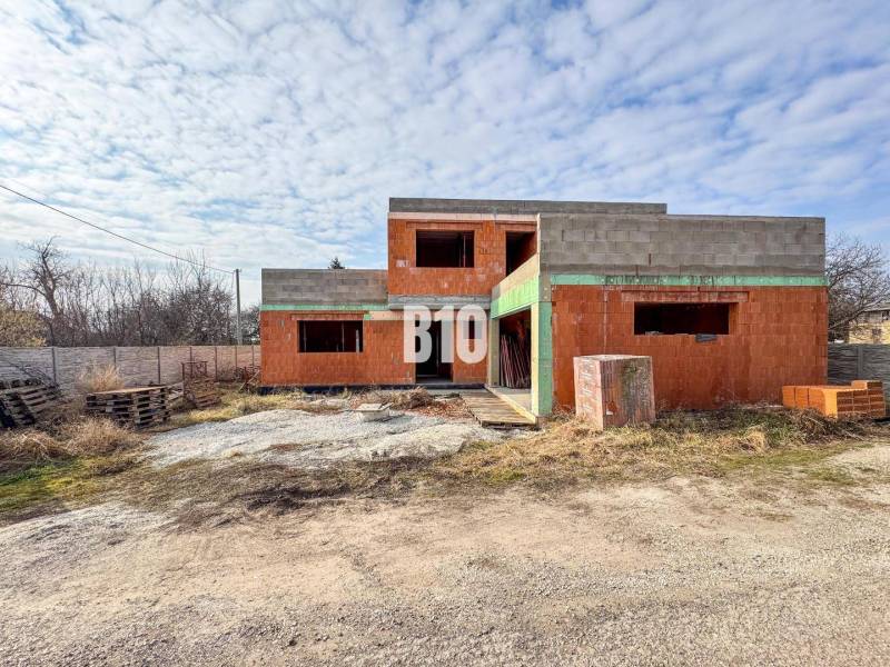 Unvollendetes Einfamilienhaus aus Ziegeln in ruhiger Umgebung, ideal für zukünftige Besitzer.