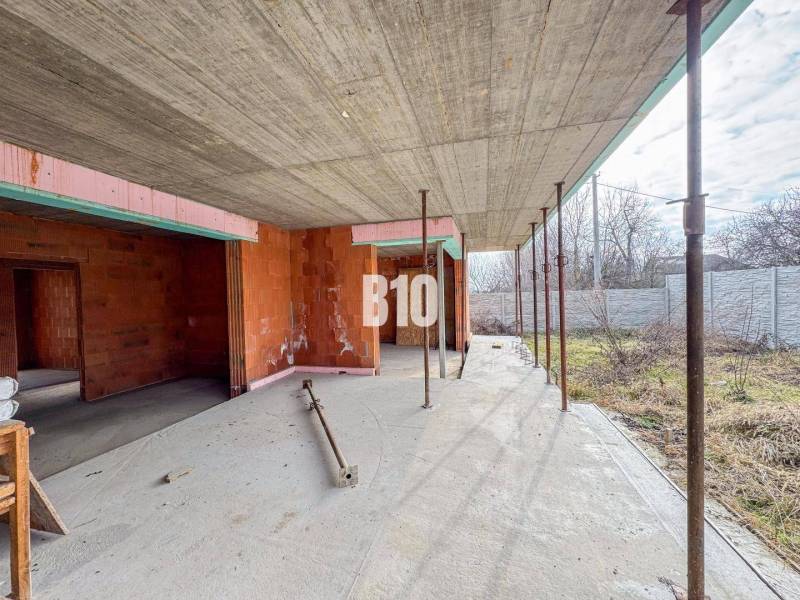 Der Bau eines Einfamilienhauses mit Ziegelwänden auf einem geräumigen Grundstück in der Natur.