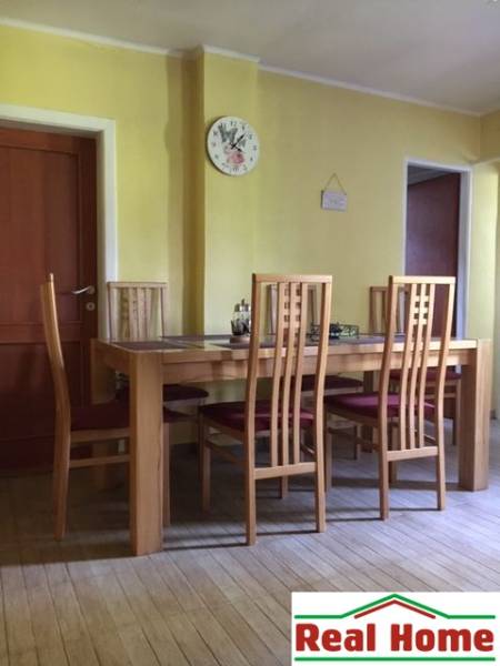 Esszimmer in einem Einfamilienhaus mit Stühlen und einem Tisch auf einem Boden mit Holzdekor.