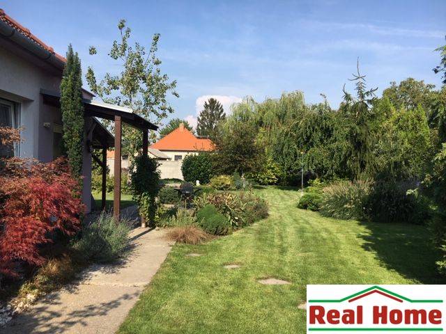 Garten beim Einfamilienhaus in Čierna Voda mit Rasen und Grünflächen.