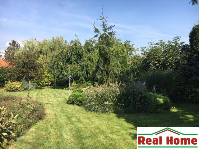 Garten bei einem Einfamilienhaus in Čierna Voda mit üppigem Grün und Rasen.