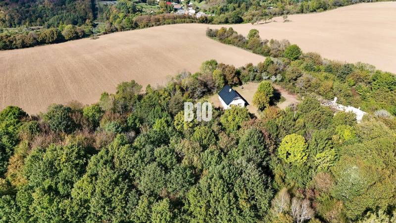 Eine Hütte in Lackov, umgeben von Wald und Feldern, eine ruhige ländliche Landschaft.