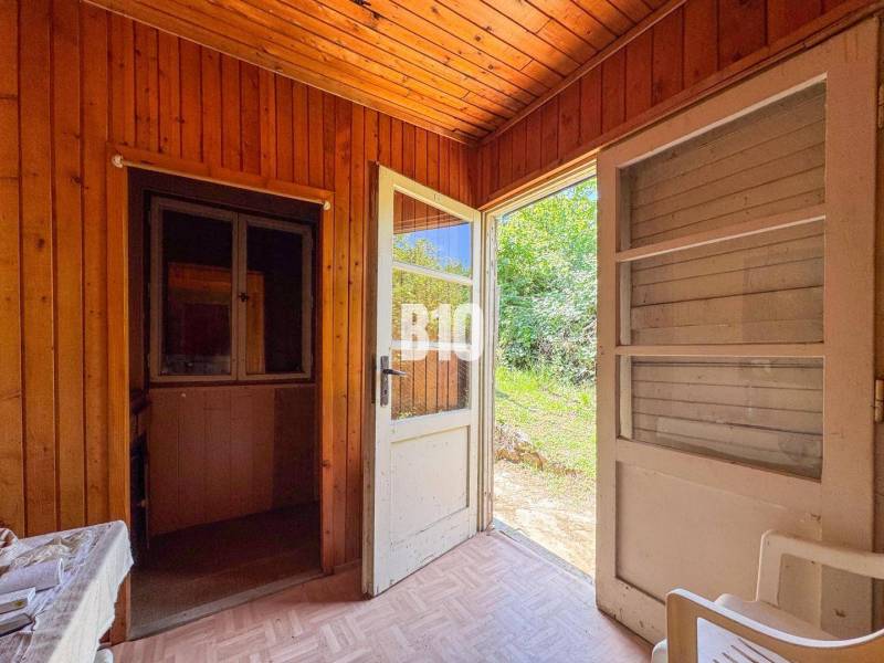 Holzinterieur der Hütte mit offenen Türen zum Garten, Weinberge.
