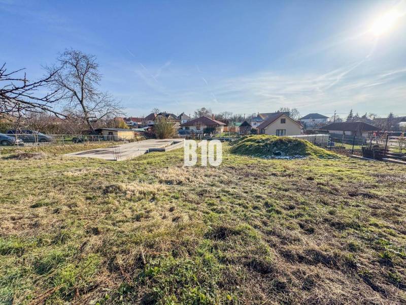 Baugrundstück mit Rasen, Hausfundament umgeben von Grün, ideal zum Wohnen.