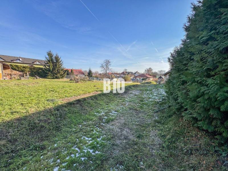 Auf dem Bild ist ein grünes Grundstück mit Häusern zu sehen, das sich zum Wohnen eignet.