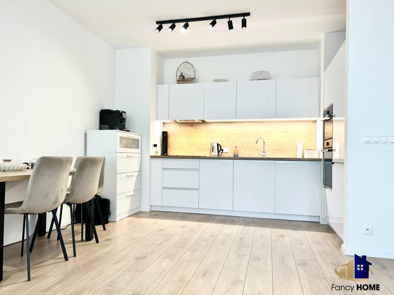 Küche in einer 2-Zimmer-Wohnung mit Holzboden und Esstisch.