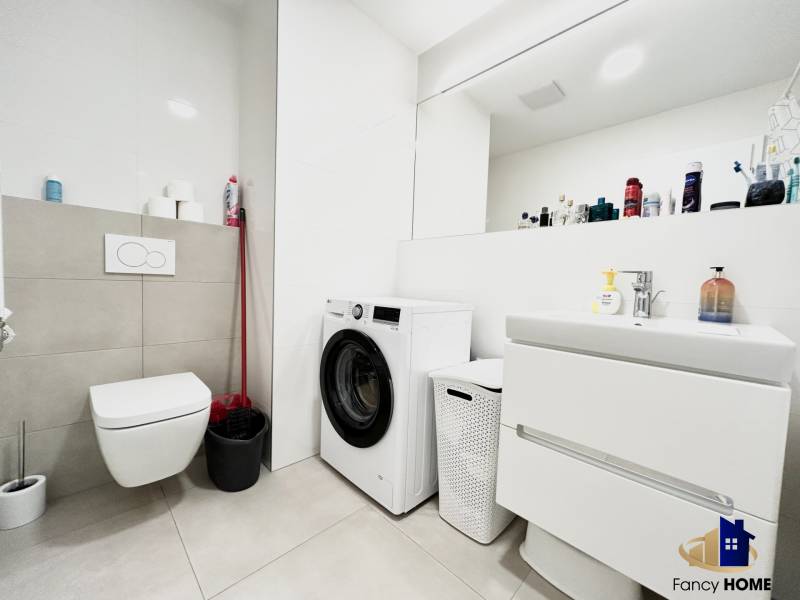 Badezimmer in einer 2-Zimmer-Wohnung mit Waschmaschine und modernen sanitären Einrichtungen.