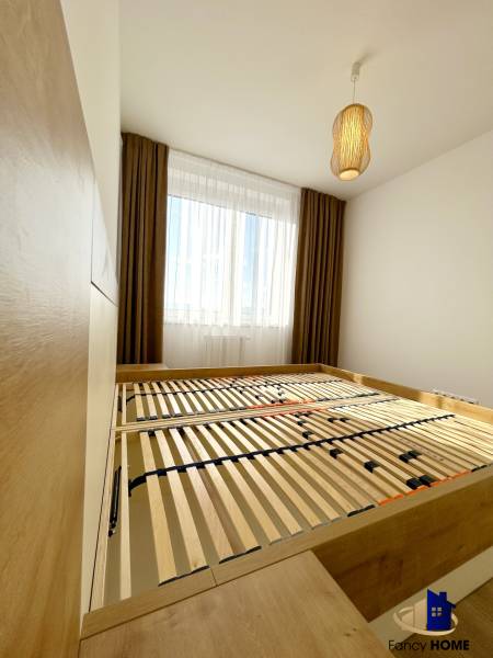 Schlafzimmer mit Bett und Lampe in einer 2-Zimmer-Wohnung mit Holzboden.