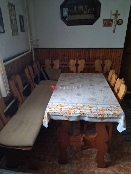 Esszimmer in einem Einfamilienhaus mit Holzstühlen und Tisch, an der Wand hängen Bilder und ein Kreuz.