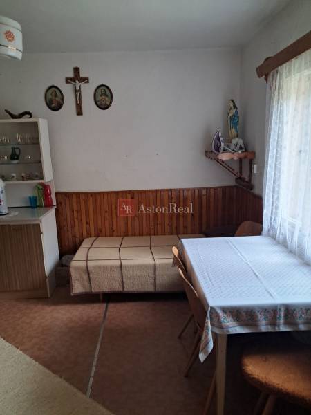 Esszimmer in einem Einfamilienhaus mit Tisch, Stühlen und religiösen Dekorationen an der Wand.