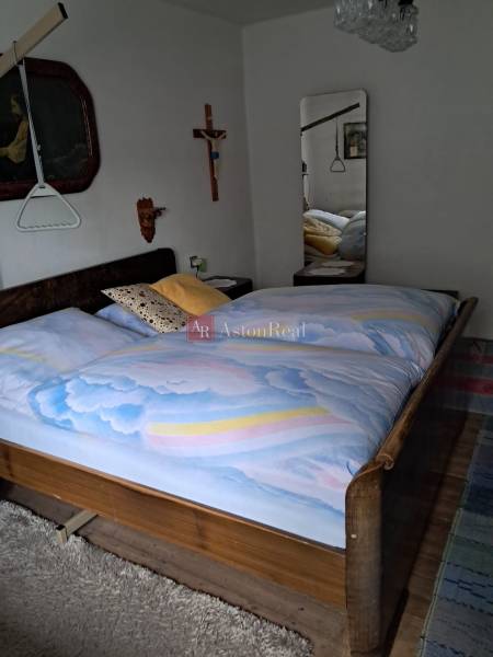 Schlafzimmer in einem Einfamilienhaus mit Holzelementen, großem Spiegel und Wanddekorationen.