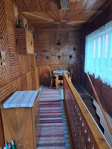 Innenraum eines Einfamilienhauses mit Holzboden und traditionellen Wanddekorationen.