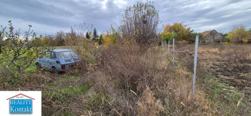 Grundstück zum Wohnen in Tvrdošovce mit einem verlassenen Auto und überwuchertem Gelände.