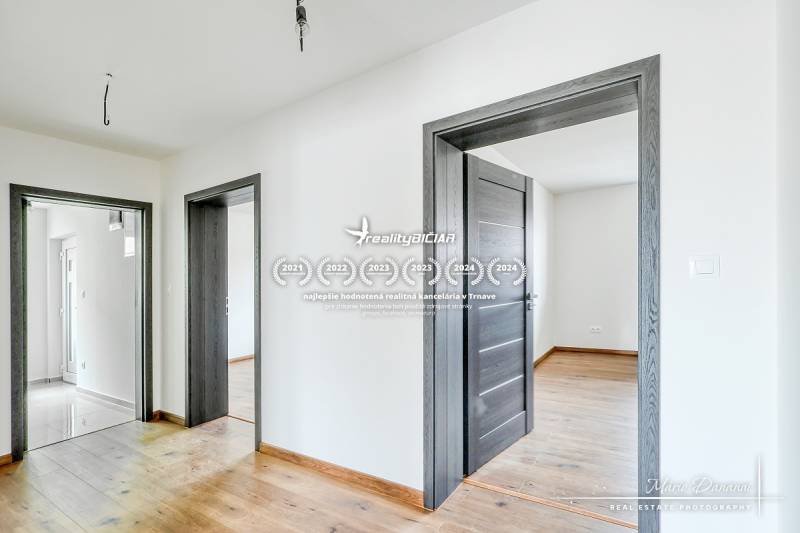 Innenraum eines Einfamilienhauses mit Holzboden und weißen Wänden.