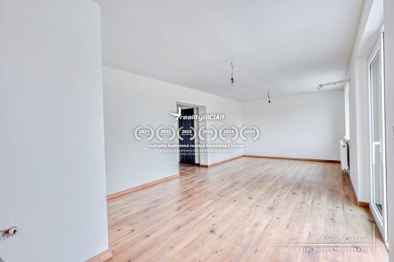 Ein geräumiges Zimmer in einem Einfamilienhaus mit Holzboden und weißen Wänden.