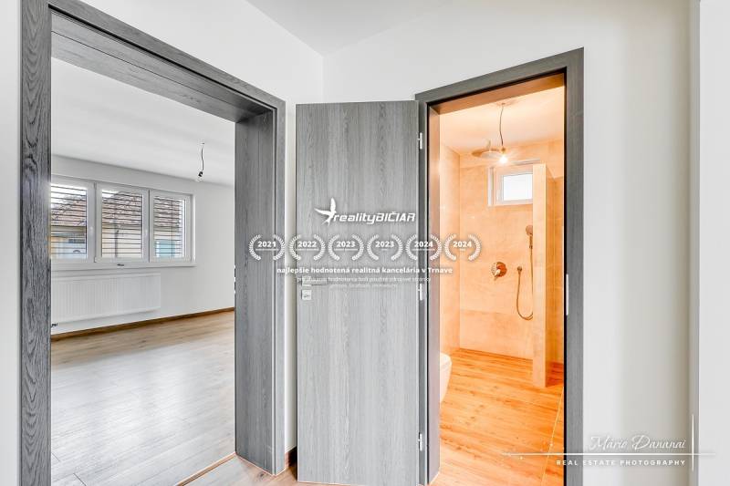 Innenraum eines Einfamilienhauses mit Türen, Badezimmer und Boden in Holzoptik.