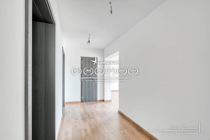 Der Flur in einem Einfamilienhaus mit einem Boden in Holzoptik und Türen in Anthrazitfarbe.