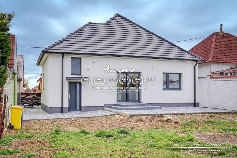 Ein Einfamilienhaus in der Orechová-Straße in Jaslovské Bohunice mit einem Rasenhof und befestigten Gehwegen.