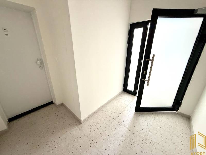 Eingangsflur in einer 2-Zimmer-Wohnung mit Glastüren.