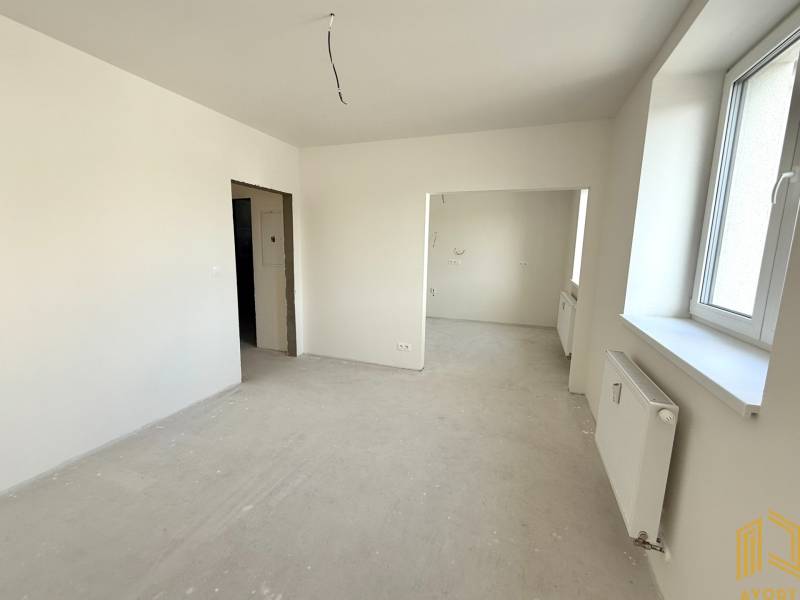 Helles Zimmer, großes Fenster, weiße Wände und Heizkörper in einer 2-Zimmer-Wohnung.