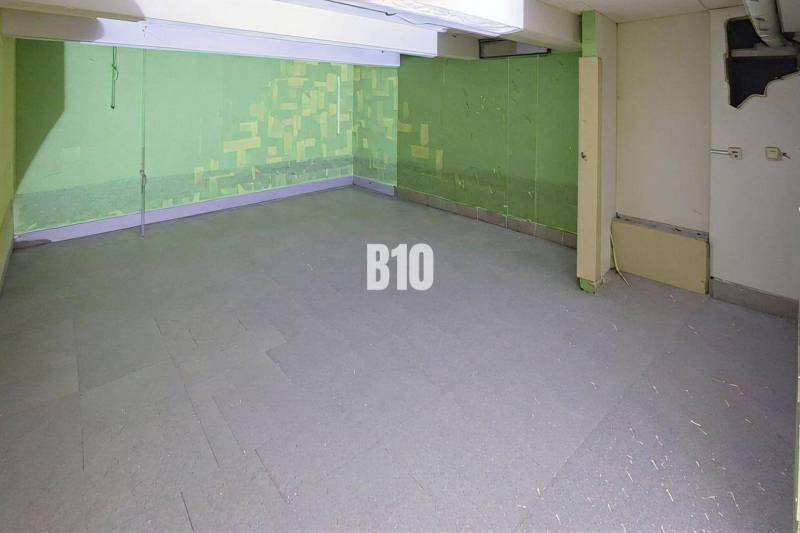 Geschäftsräume mit Betonboden und grünen Wänden.