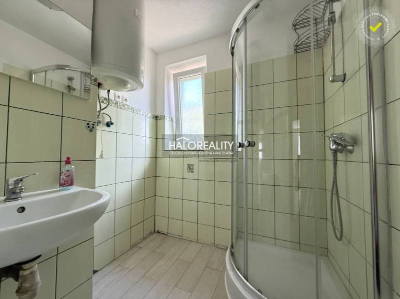Badezimmer in einer 3-Zimmer-Wohnung mit Waschbecken, Duschkabine und Fenster.