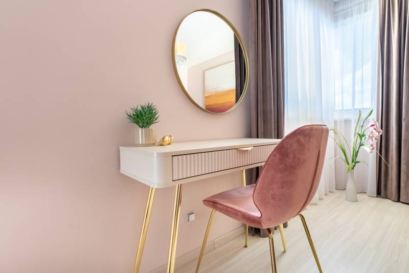 Innenraum eines Einfamilienhauses mit Schminktisch, Spiegel und dekorativen Elementen.