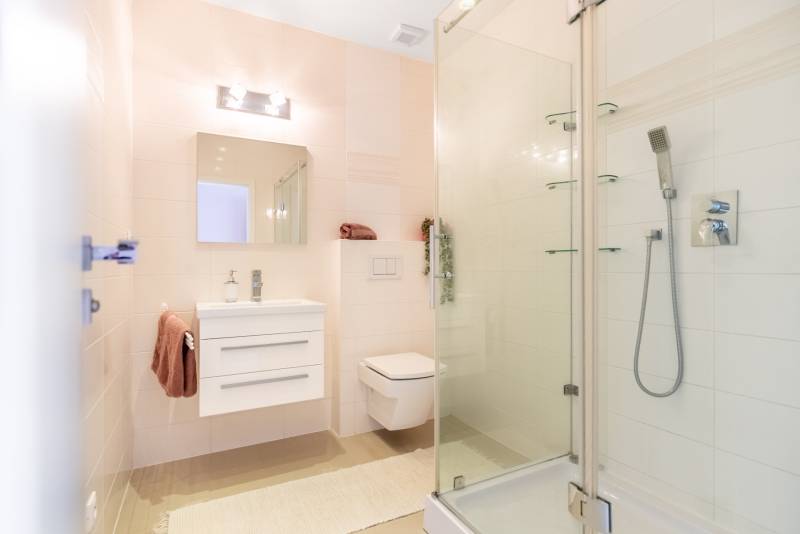 Ein Badezimmer in einem Einfamilienhaus mit Waschbecken, Duschkabine und Toilette.