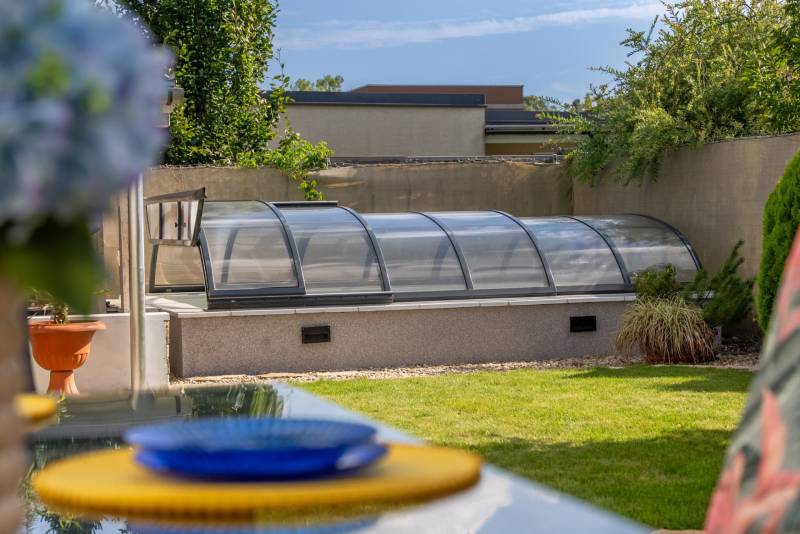 Garten mit einem Pool, der von einem verglasten Unterstand in einer 4-Zimmer-Wohnung in der Jazdecká-Straße in Trnava überdacht ist.