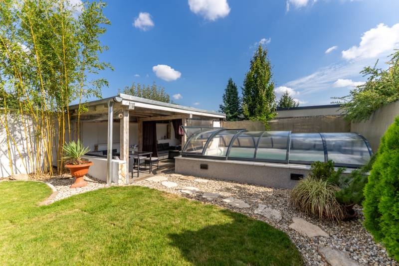 Der Garten eines Einfamilienhauses in der Jazdecká-Straße in Trnava mit einem Pavillon und einem überdachten Pool.