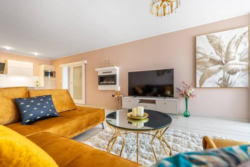 Wohnzimmer mit dekorativem Bild, Sofa und Tisch in einem Einfamilienhaus.