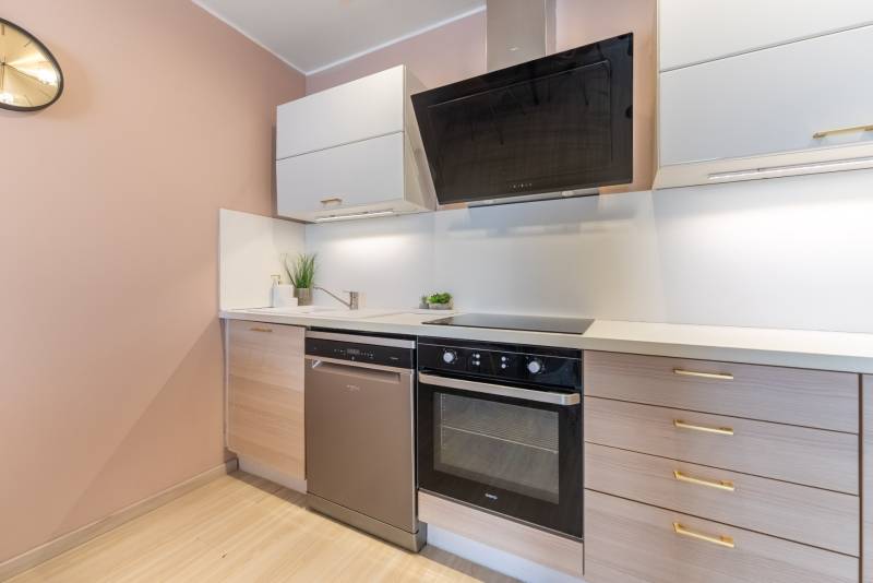 Küche in einer 4-Zimmer-Wohnung mit Holzboden und modernen Geräten.