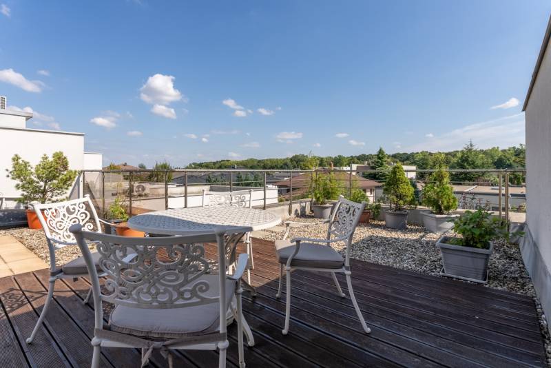 Die Terrasse des Einfamilienhauses in der Jazdecká-Straße in Trnava mit Blumenkästen und Sitzgelegenheiten.