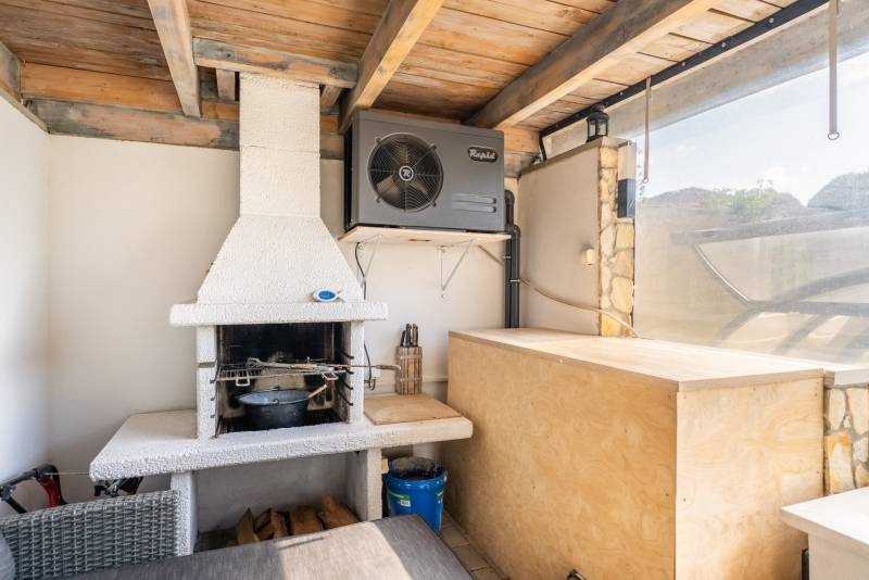 Überdachte Terrasse in einer 4-Zimmer-Wohnung mit Kamin und Klimaanlage.