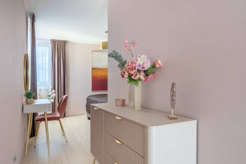 Blumendekoration auf der Kommode, Spiegel, Stuhl und Boden mit Holzdekor in einem Einfamilienhaus.