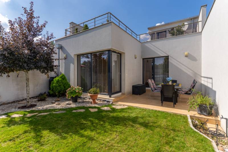 Der Garten des Einfamilienhauses in der Jazdecká-Straße in Trnava mit Rasen und Terrasse.