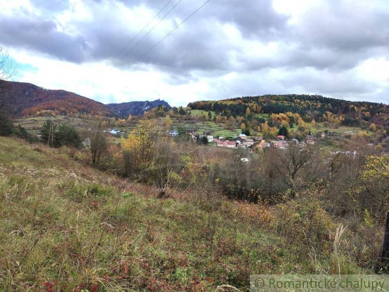 Herbstlandschaft in Hlboké nad Váhom mit einem bunten Wald und einem Dorf im Tal.