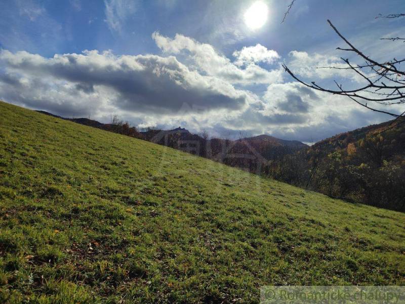 Sonnenlandschaft in Hlboké nad Váhom, Gärten, Gras, Bäume, Hügel, Wolken am Himmel.