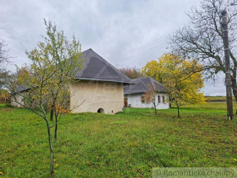 Ein Einfamilienhaus in Senohrad, umgeben von Bäumen und einem grasbewachsenen Garten im Herbst.