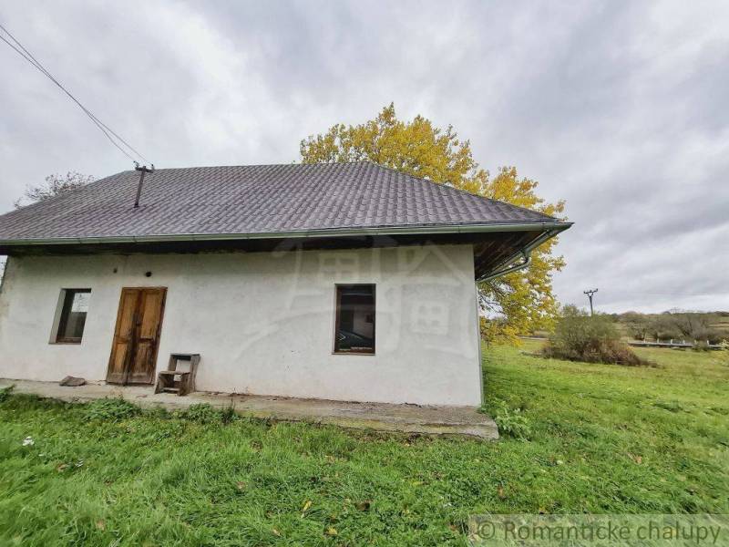 Ein Einfamilienhaus in Senohrad mit einer einfachen Fassade, umgeben von Natur und einem grasbewachsenen Grundstück.