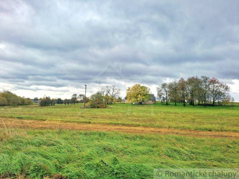 Ein Einfamilienhaus in Senohrad, umgeben von Grün und Bäumen unter einem bewölkten Himmel.