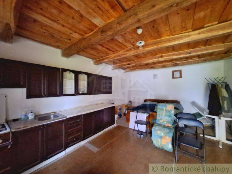 Eine Küche in einem Einfamilienhaus mit einer Holzdecke und einer Küchenzeile in dunkler Farbe.