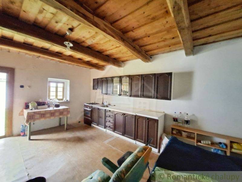 Eine Küche in einem Einfamilienhaus mit einer Holzdecke, Schränken und einem Boden mit Holzdekor.